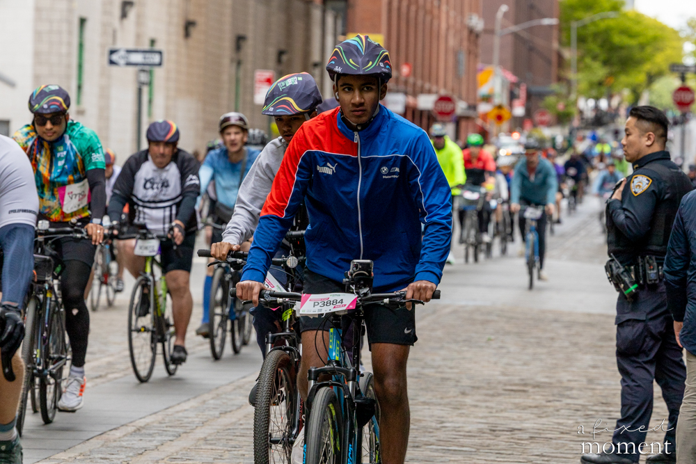 Cyclists move through a city street during the 2026 TD Five Boro Bike Tour