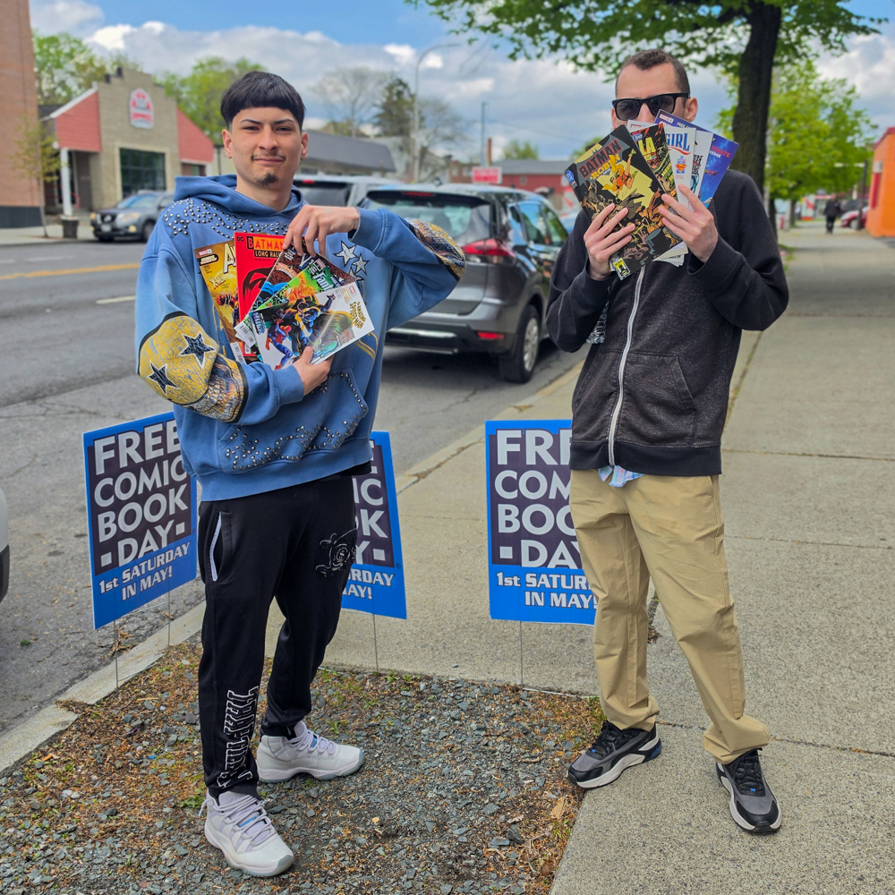 Attendees show comics during Free Comic Book Day at Earthworld Comics in Albany, New York