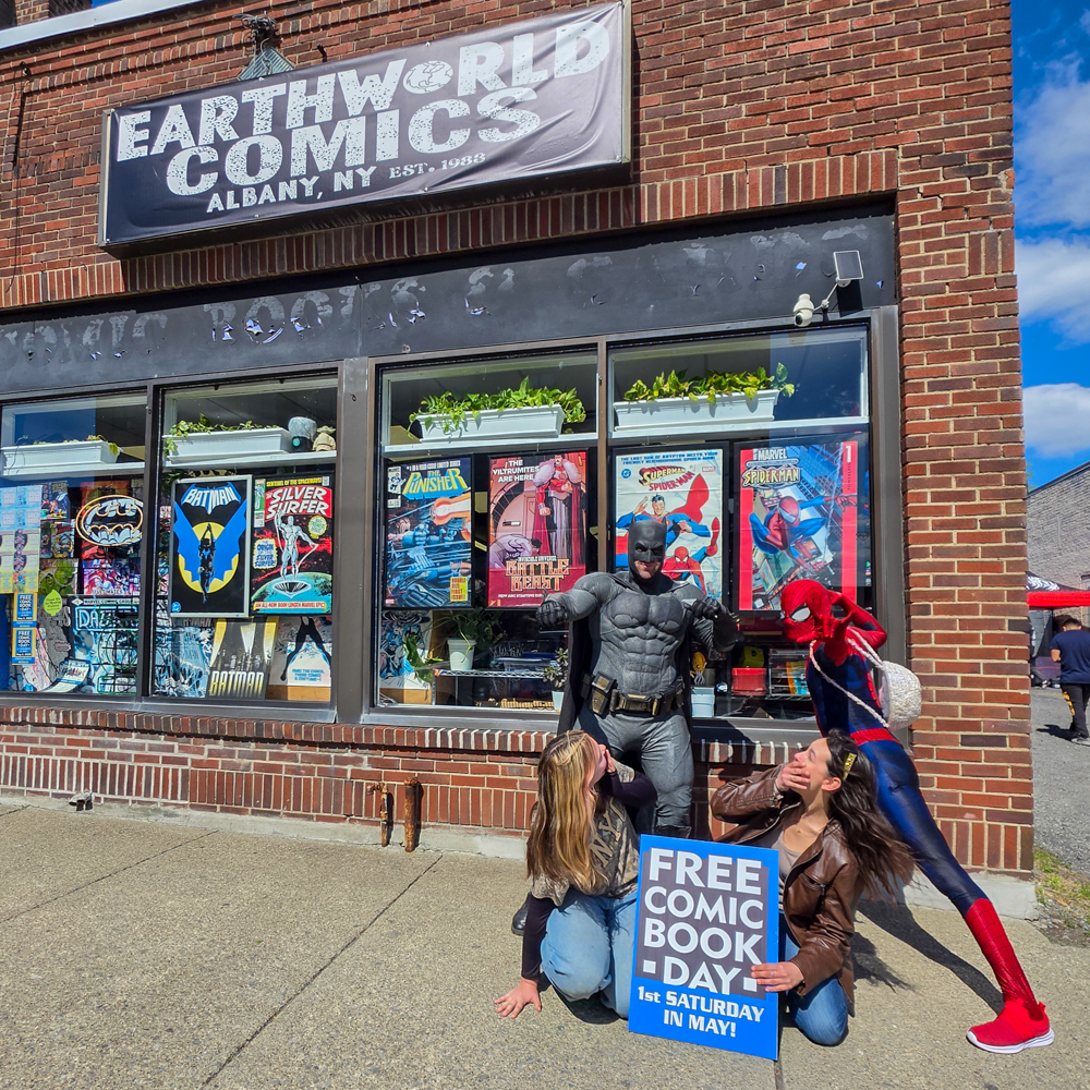 Batman and Spiderman cosplayers pose during Free Comic Book Day at Earthworld Comics in Albany, New York
