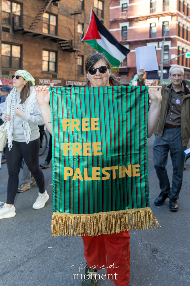 A participant holds a Free Free Palestine banner