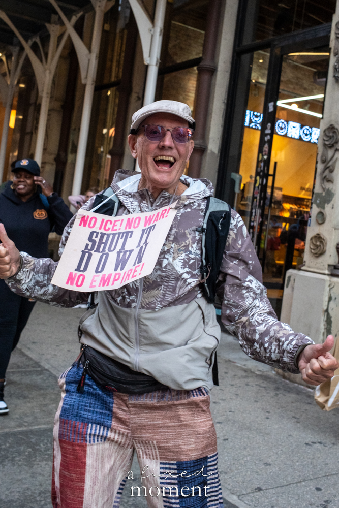 A participant wears a No ICE No War sign