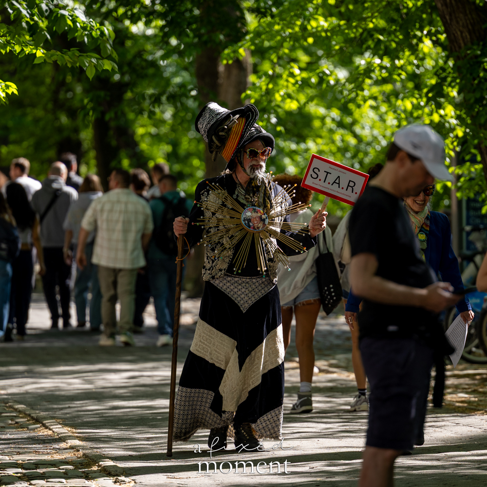 Costumed participant with a S.T.A.R. sign outside the Met Gala during the Resistance Red Carpet protest