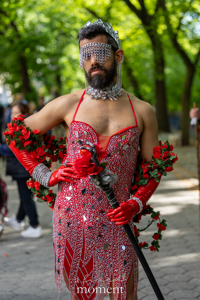 Helisian poses in a red rhinestone costume with mirrored details outside the Met Gala