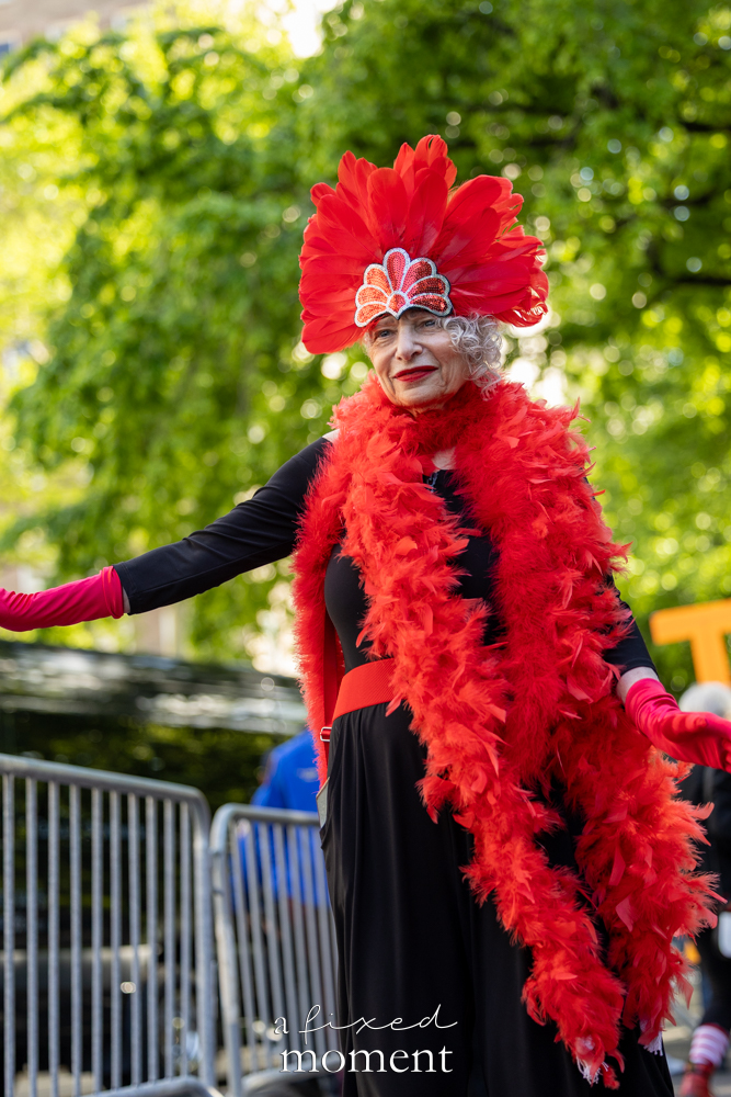 Participant in a red feather costume poses outside the Met Gala during the Resistance Red Carpet protest