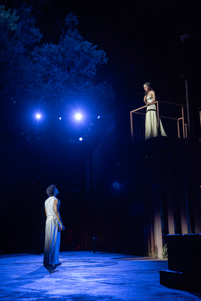 Ra’Mya Latiah Aikens as Juliet stands above Daniel Bravo Hernández as Romeo during the balcony scene in The Public Theater’s Romeo and Juliet