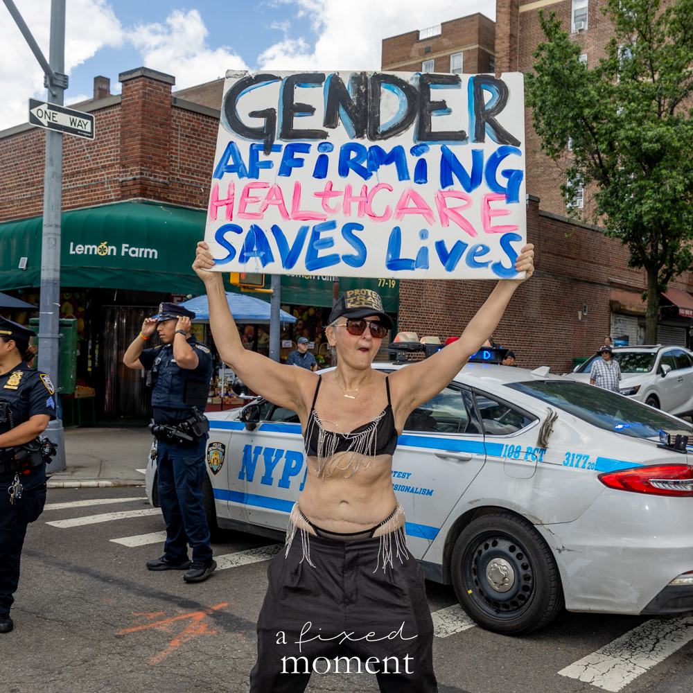 A Gender Affirming Healthcare Saves Lives sign is carried during the New Queens Pride Parade in Jackson Heights, Queens.