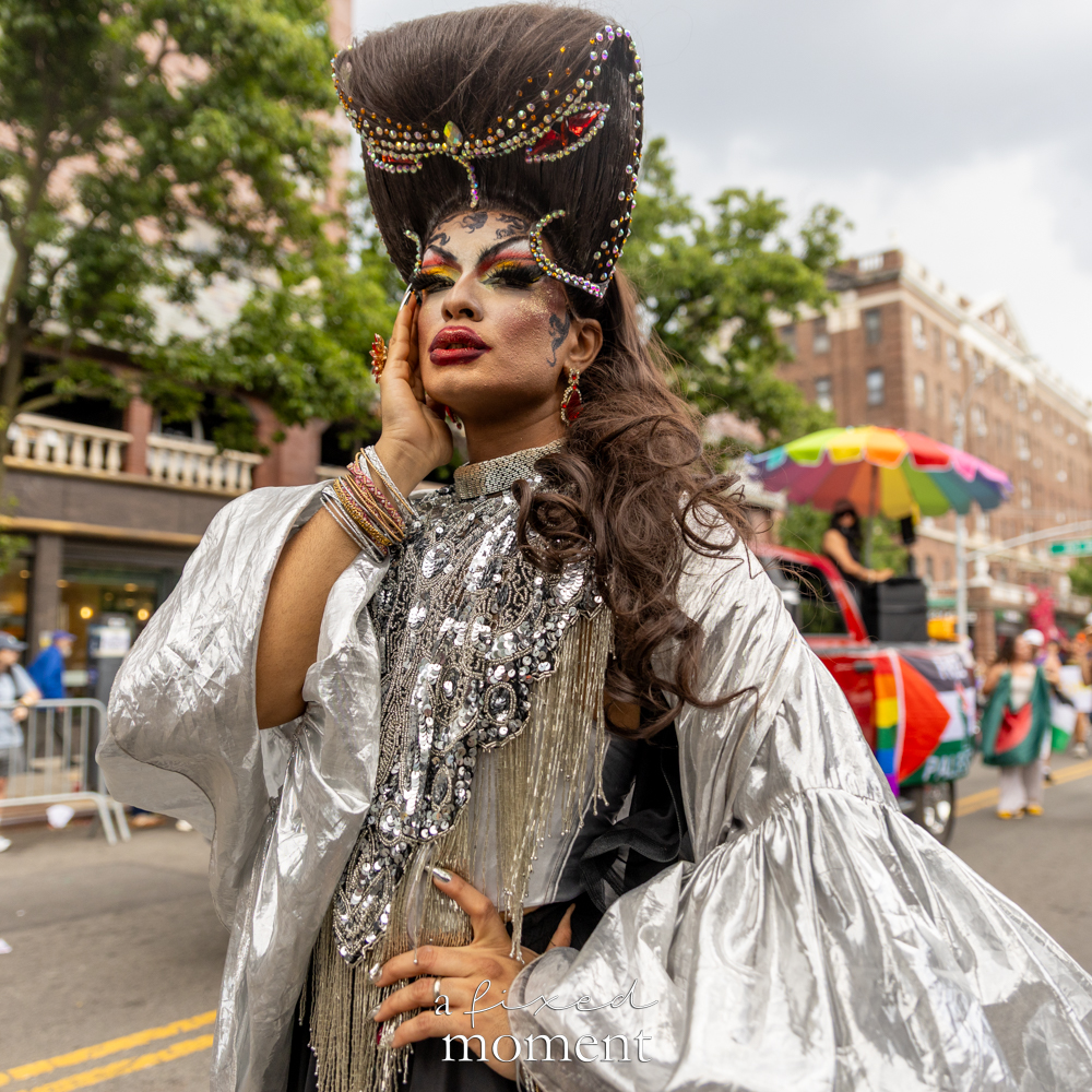 Malai performs in a silver costume at Queens Pride.