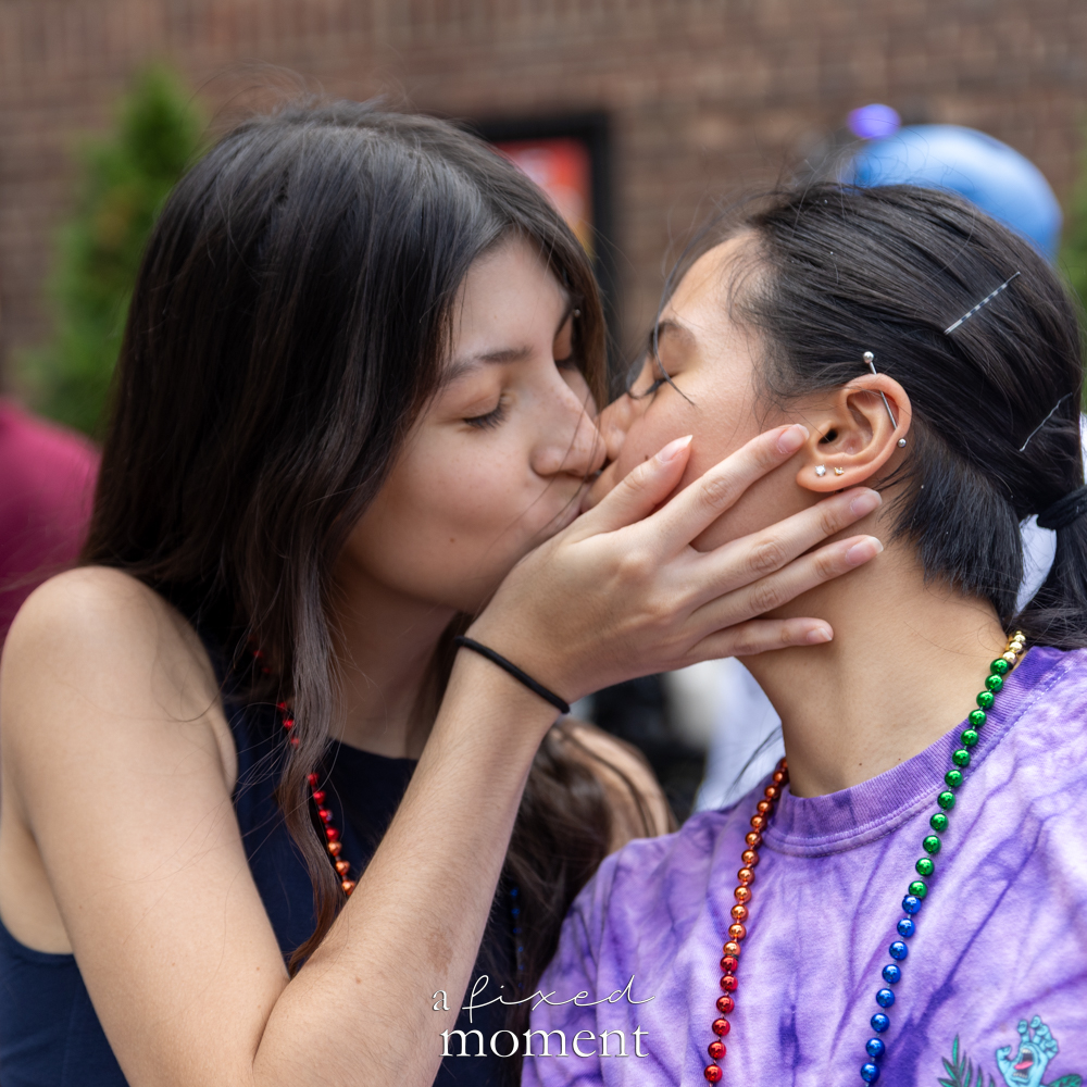 Two attendees kiss during the New Queens Pride Parade.