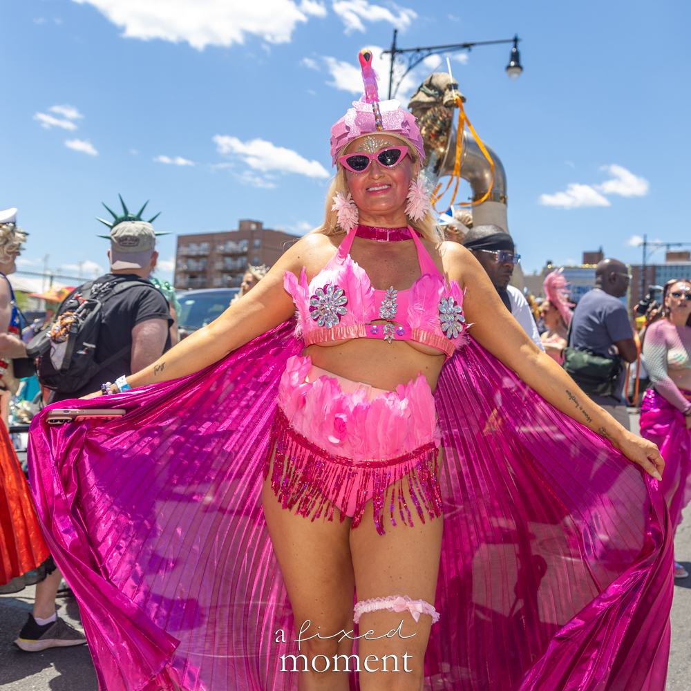 @happyeverything_art in a bright pink flamingo-inspired costume at the Mermaid Parade.