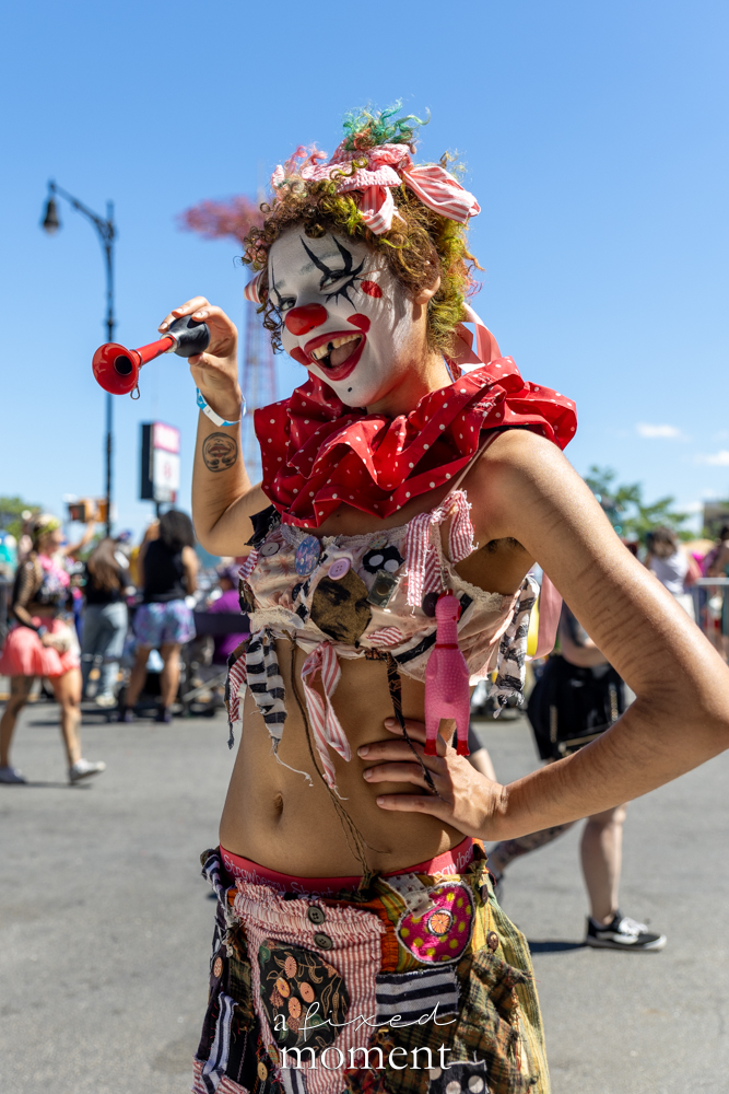 Red clown costume with horn portrait at the Mermaid Parade.