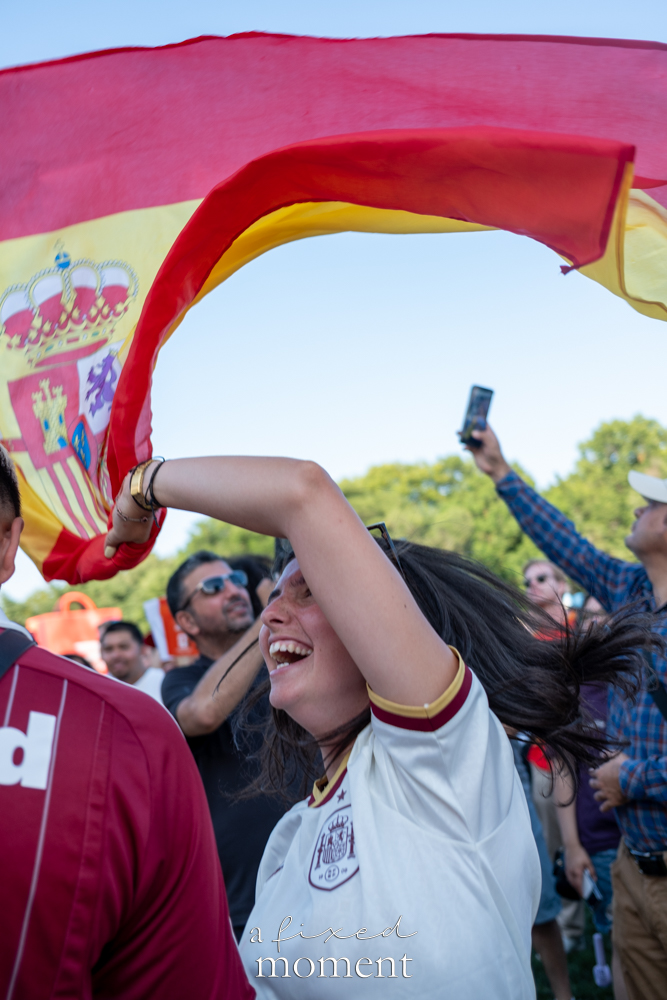 Spanish flag spread above supporters celebrating in Central Park