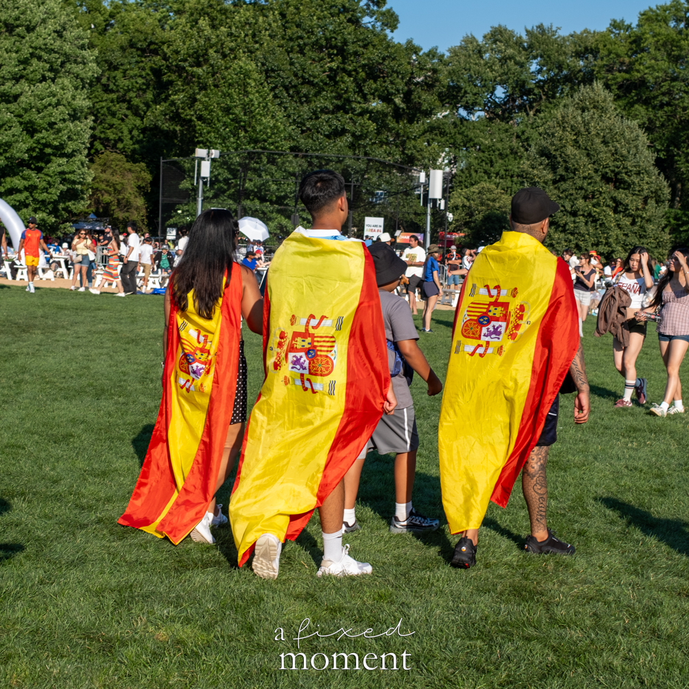 Spain supporters leaving Central Park with national flags draped over their shoulders