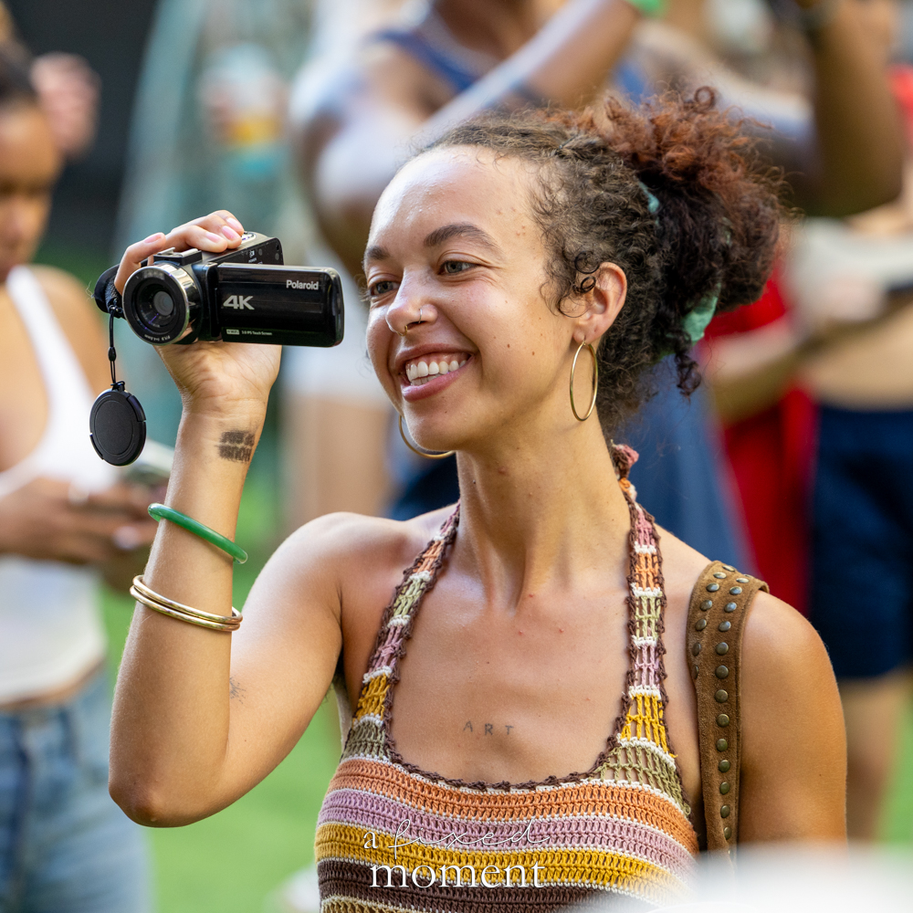 Attendee with Polaroid camera and camcorder at House of GOAL in Brooklyn