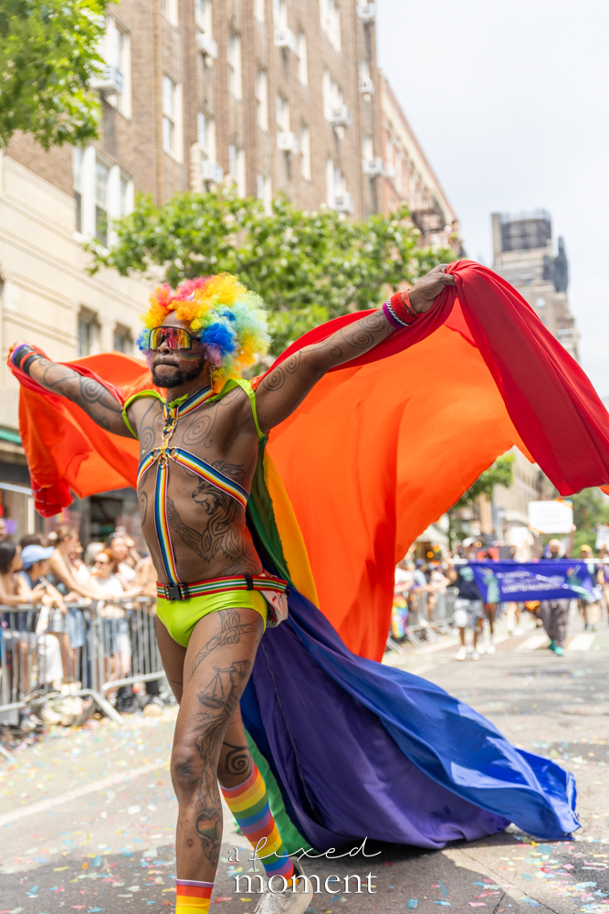 Rainbow cape performer street portrait during NYC Pride March 2026