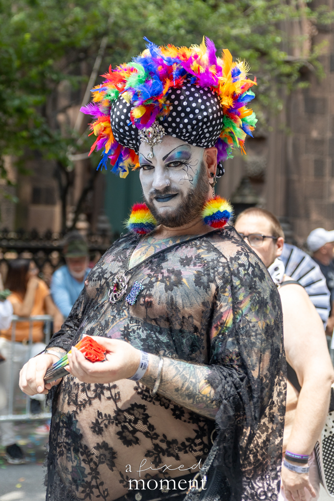Rainbow feather performer in lace costume at NYC Pride March 2026