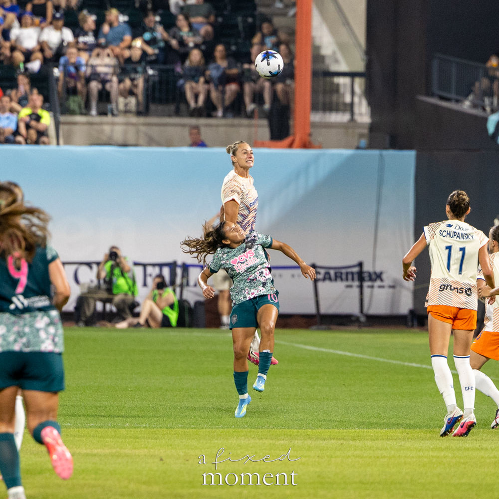 Gotham FC and Washington Spirit players competing for an aerial ball