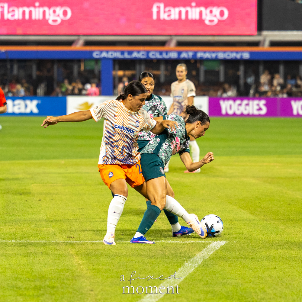 Gotham FC and Washington Spirit players in a physical possession battle