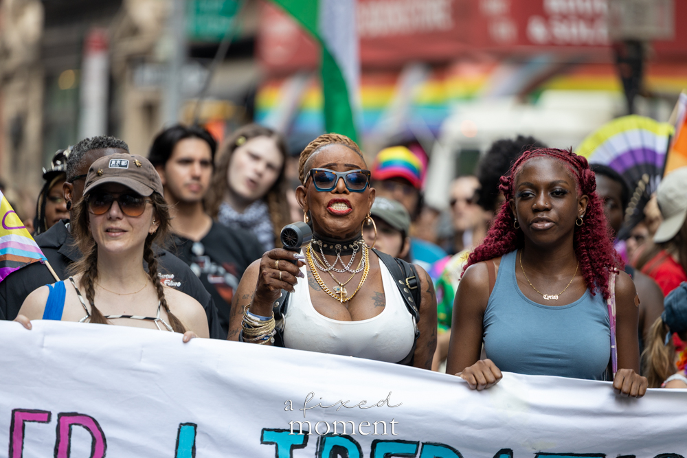 Marchers with the Queer Liberation March front banner and microphone in New York City