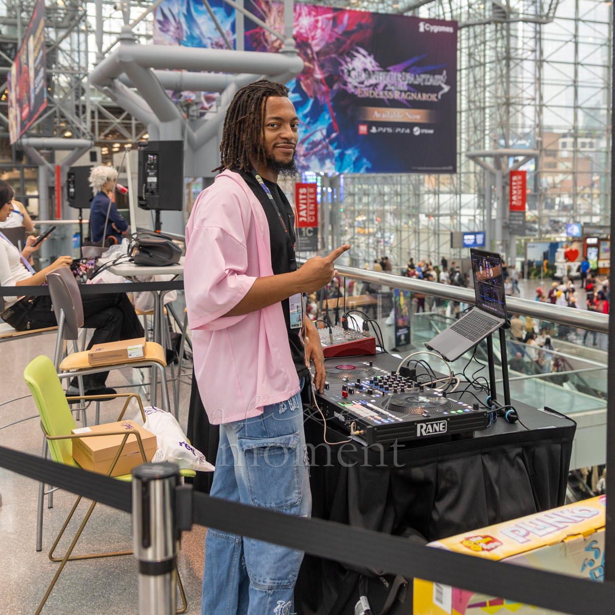 DJ works from an upper-level booth overlooking the Javits Center atrium during Anime NYC 2026