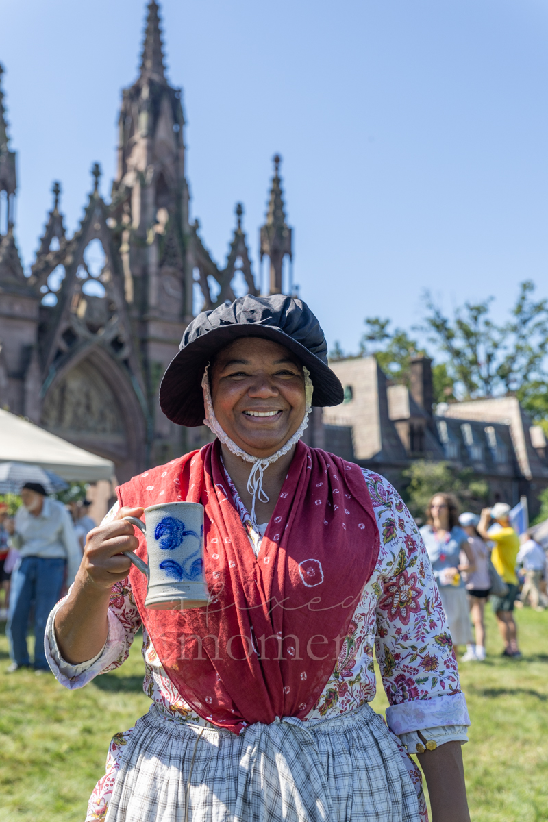 Historical interpreter holding a ceramic mug during the Battle of Brooklyn 250 program