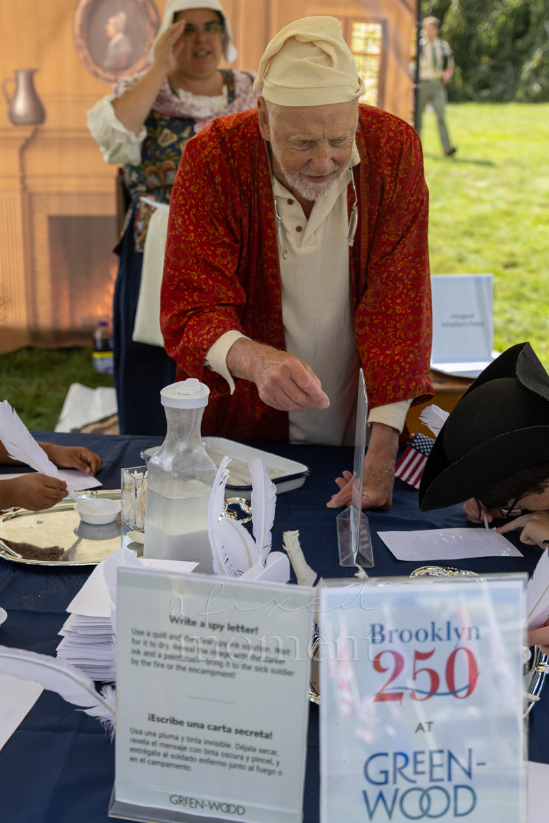 Visitors participate in a spy letter activity during the Battle of Brooklyn 250 program
