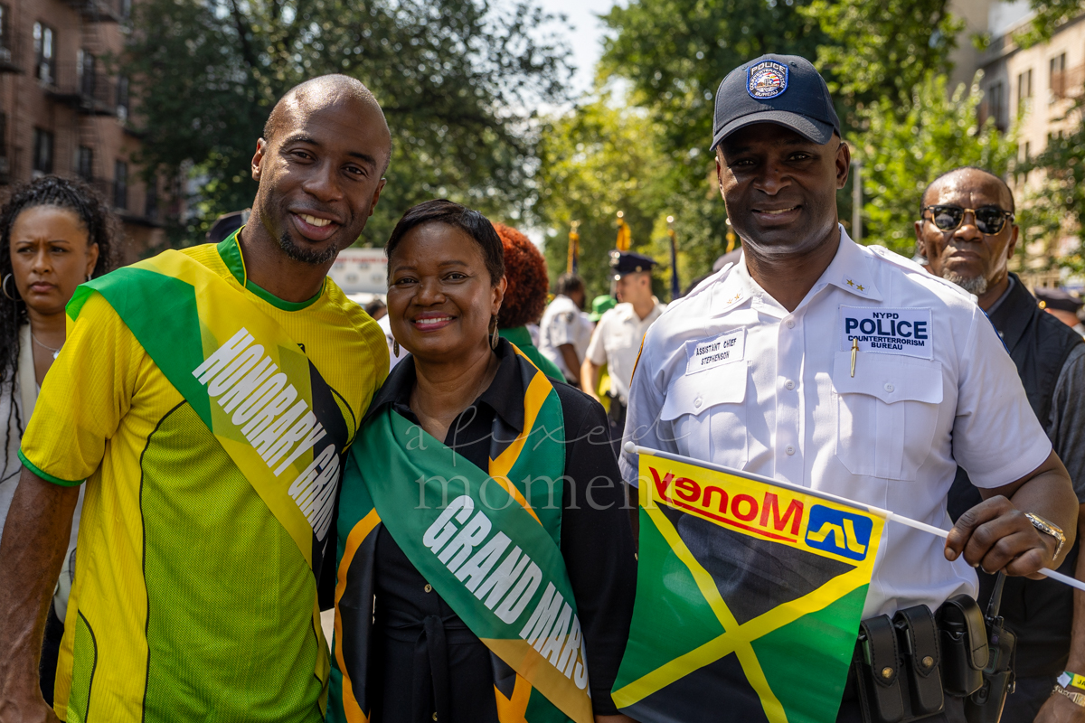 Jamaican singer Nadine Sutherland stands between an honorary grand marshal and NYPD Assistant Chief Ruel Stephenson