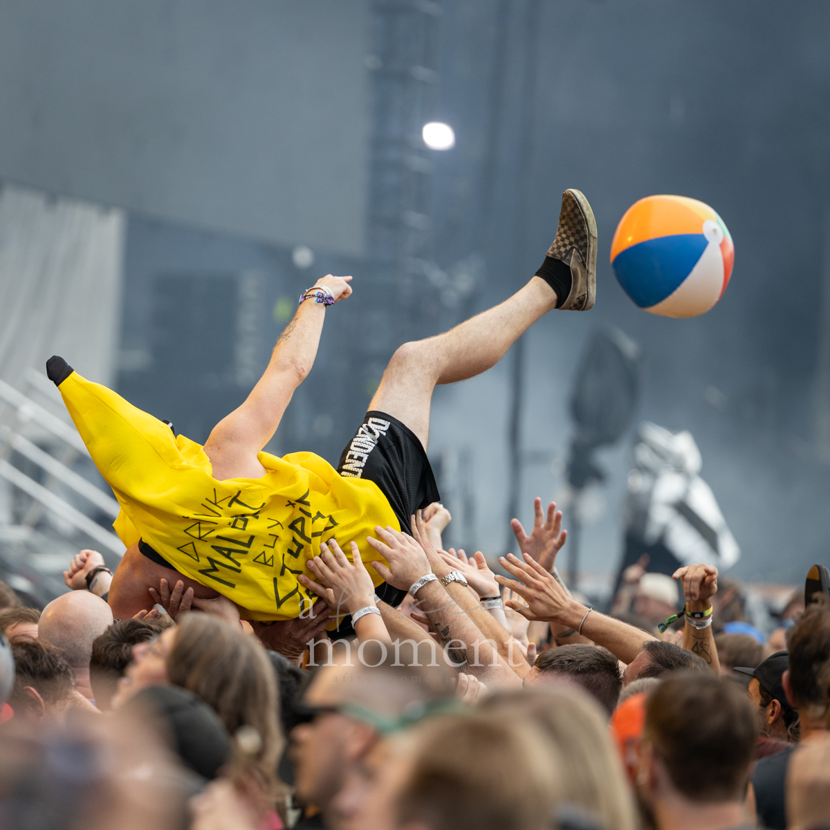 Festivalgoer in a bright yellow banana costume crowd surfs beside a beach ball during Alkaline Trio at Riot Fest 2026 in Chicago