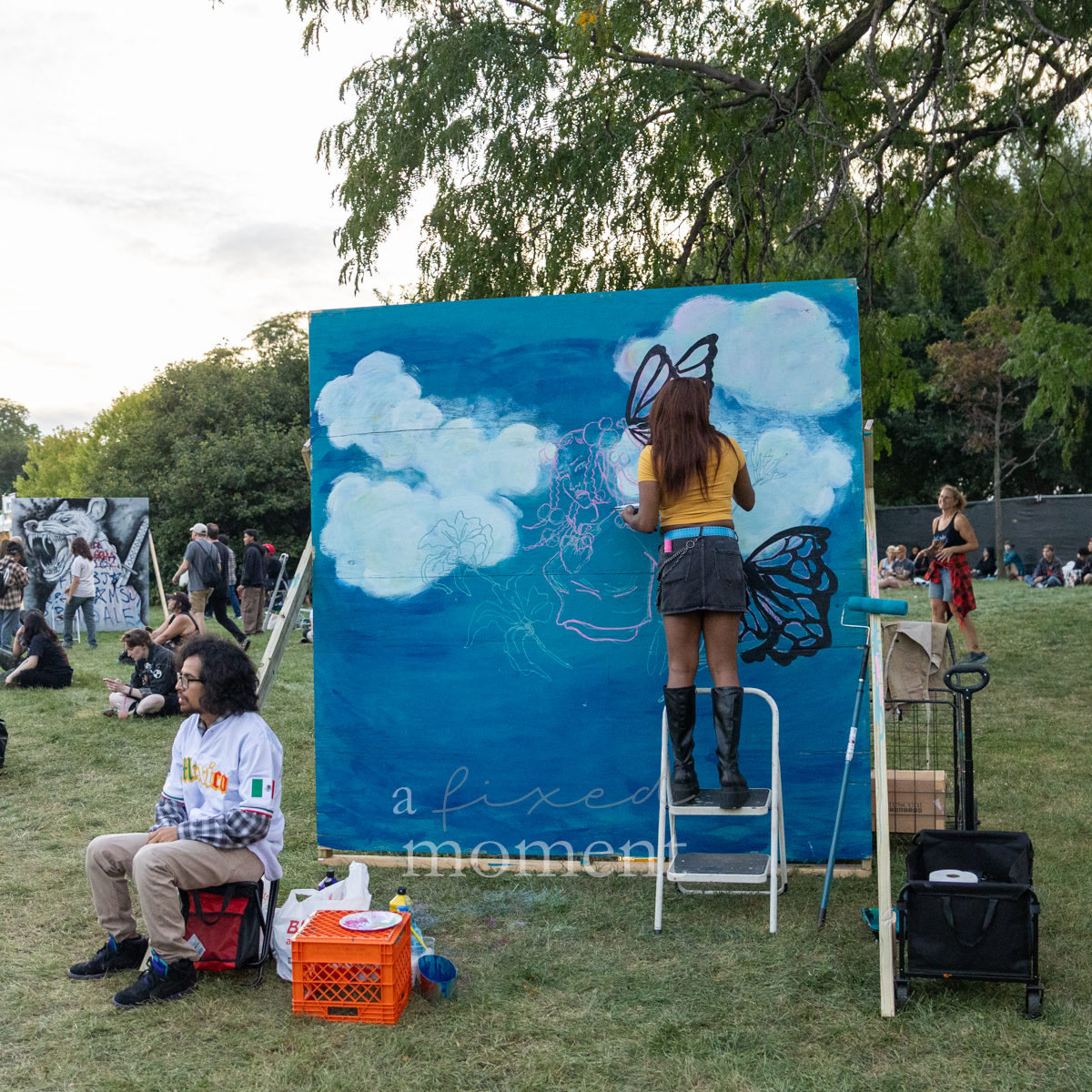 Artist paints a butterfly mural during Riot Fest 2026