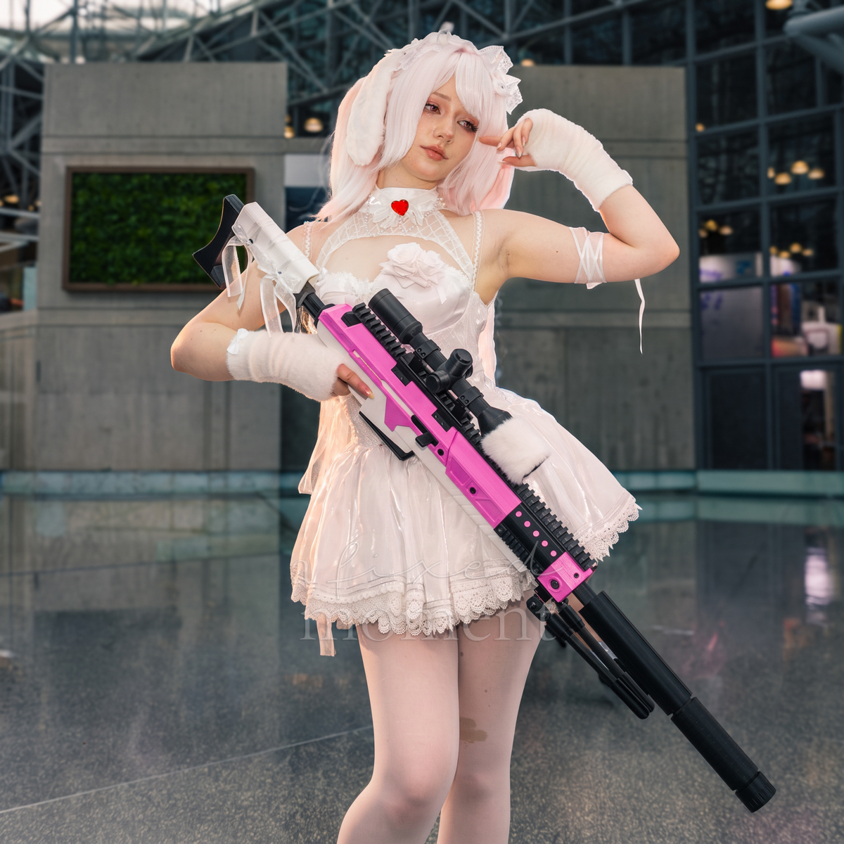 @strawbemees in white Lolita-inspired cosplay with a prop rifle at Anime NYC 2026 Day Two