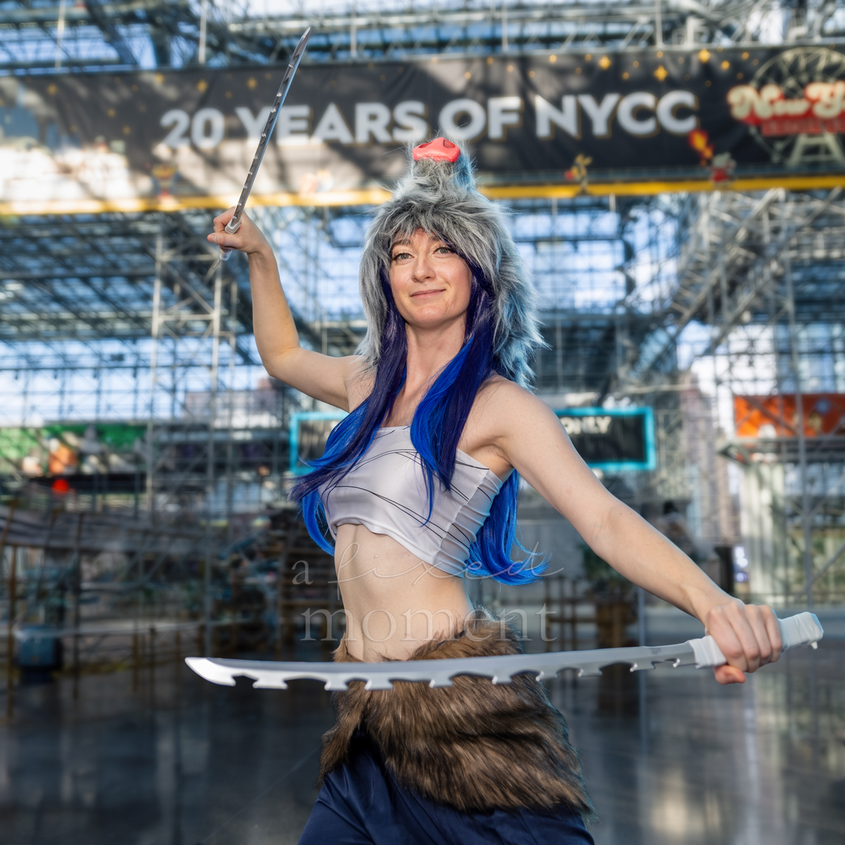 Blue-haired cosplayer posing with a sword at New York Comic Con 2026