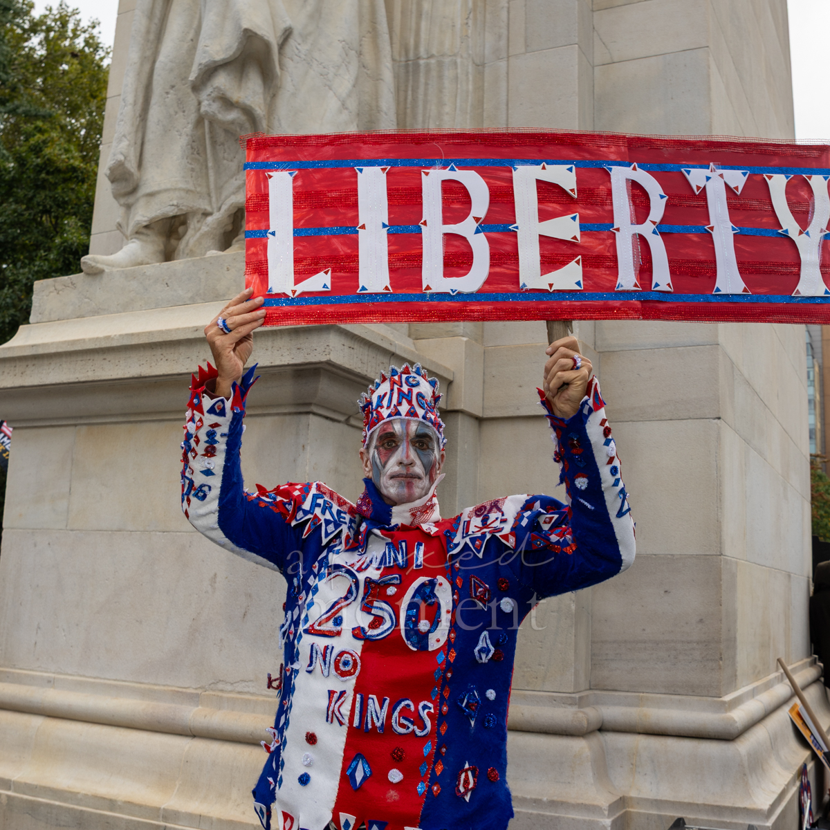 An attendee raises a Liberty sign beneath the Washington Square Arch.