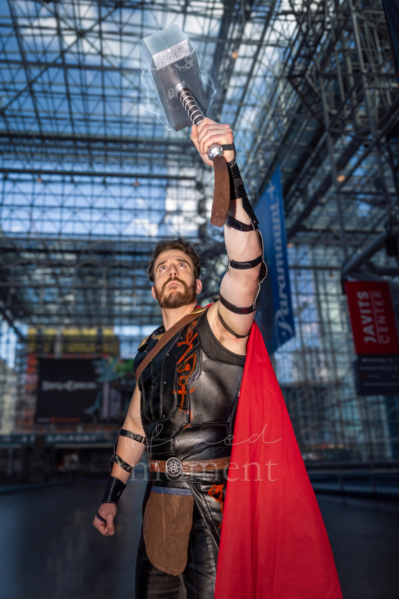 Thor cosplayer raising Mjolnir at New York Comic Con 2026