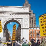 A powerful moment from the 50 50 1 march in New York City on February 17, 2025, shows demonstrators gathered at Washington Square Park, holding large yellow protest signs that read: "In the Name of Humanity, We REFUSE to Accept a Fascist America!" The signs, branded with RefuseFascism.org, are prominently displayed in the foreground, held high by multiple protesters.
The Washington Square Arch, an iconic symbol of democracy and public gathering, stands in the background against a clear blue sky. Protesters are seen engaging in conversations, holding additional signs with political messages, and standing together in solidarity. Many are bundled up in winter clothing, wearing hats, scarves, and heavy coats.
This moment captures the conclusion of the march, which started at Union Square and ended at Washington Square Park, drawing a diverse crowd advocating for resistance against fascism, social justice, and democracy.