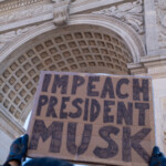 A demonstrator raises a large cardboard sign reading "IMPEACH PRESIDENT MUSK" in bold, black hand-drawn letters during the 50 50 1 march in New York City on February 17, 2025. The sign is held high against the backdrop of the Washington Square Arch, an iconic monument in the city's history of activism and resistance.
The protester, whose face is not visible, is wearing black gloves while gripping the sign firmly. The angle of the shot emphasizes the scale of the message against the arch’s intricate architectural details, including the sculpted eagle at its peak. The clear blue sky and bright sunlight highlight the strong contrast between the protest sign and the grand structure, symbolizing the pushback against perceived authoritarianism.
This moment captures the spirit of civic engagement and political activism, with demonstrators rallying to express their opposition through peaceful protest.