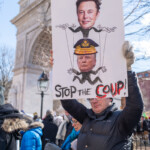 A protester at the 50 50 1 march on February 17, 2025, in New York City holds a large satirical sign depicting Elon Musk as a puppet master controlling Donald Trump, who is illustrated wearing a military general’s hat. The sign features bold text reading "STOP THE COUP!" with "COUP" emphasized in red.
The demonstrator, wearing a black puffer jacket, a beanie, and white gloves, stands in front of the Washington Square Arch, a landmark that serves as a backdrop to many political demonstrations in NYC. Other protesters in warm winter attire fill the background, contributing to the march’s atmosphere of political engagement and resistance.
The 50 50 1 march attracted activists concerned about threats to democracy, authoritarianism, and corporate influence in politics. The visual metaphor of Musk controlling Trump through puppet strings suggests criticism of wealthy elites’ influence on governance and democratic institutions. The powerful imagery, combined with the handwritten message, underscores the protester’s concerns over authoritarianism and election integrity.
