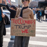 A demonstrator at the Picket Tesla protest on March 1, 2025, at 860 Washington Street, NYC, participates in the satirical "Trillionaires for Trump" performance, mocking the extreme wealth gap. The protester wears a luxurious beige fur hat, oversized sunglasses, a shimmering gold sweater, a black scarf, and gray wide-leg pants, embodying the persona of an elite billionaire. She holds a hand-drawn sign that reads:
"Trillionaires for Trump – Even WE Can't Afford Eggs!"
This exaggerated statement underscores the rising cost of living and the broader critique of corporate greed and economic inequality. In the background, other protesters hold signs, including one that reads "Boycott Tesla, Abolish DOGE." The setting is a crosswalk near the Tesla Showroom, with demonstrators and bystanders walking past, reinforcing the public nature of the protest.
The performative protest aligns with the broader demonstration organized by Rise and Resist NYC (@riseandresistnyc), which targets Elon Musk’s influence and corporate policies.