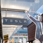 At the Picket Tesla protest on March 1, 2025, at 860 Washington Street, NYC, a demonstrator holds a large black-and-white cutout of Elon Musk, stylized in an authoritarian pose. The cutout, towering over the protesters, serves as a striking symbol of their critique of Musk’s corporate and political influence. Beneath the Tesla showroom sign, several protesters wave signs, including:
"Overthrow the Shadow President"
"NAZI NAZI NAZI"
"Your Insurance Premiums Will Fund My Private Jet"
These messages underscore the protesters’ concerns over wealth inequality, political overreach, and Tesla’s role in economic and social policies. The reflection in the showroom windows captures more demonstrators, amplifying the scale of the event. Organized by Rise and Resist NYC (@riseandresistnyc), this protest called for public action against Elon Musk’s growing influence and controversial policies.