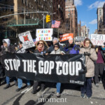 A large crowd of demonstrators at the 50 50 1 march in New York City on February 17, 2025, takes to the streets in opposition to authoritarianism and the Republican Party. At the front of the march, a group of protestors holds a large black banner reading "STOP THE GOP COUP" in bold white letters, with "RISE AND RESIST" printed in the lower right corner.
Surrounding them, other marchers carry an array of handmade protest signs, including messages such as:
"NO DICTATORS IN THE USA"
"PRESIDENTS ARE NOT KINGS"
"F’ELON AND THE FELON" (referencing Elon Musk and Donald Trump)
"MEIN TRUMPE"
"OVERTHROW THE OLIGARCHS"
American flags wave among the demonstrators, emphasizing a call to defend democracy. The scene is set against a backdrop of tall buildings lining the city streets under a clear blue sky, with bright winter sunlight illuminating the march. Protesters of diverse backgrounds, some wearing winter coats and scarves, march with determined expressions.
This powerful moment captures the urgency and intensity of political activism in Washington Square Park and the surrounding streets, where demonstrators demand accountability and resist threats to democracy.