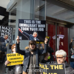 At the Picket Tesla protest organized by Rise and Resist (@risenresistnyc) on March 1, 2025, outside the Tesla Showroom at 860 Washington Street, NYC, demonstrators hold provocative signs denouncing Elon Musk and corporate influence.
In the foreground, a protester wearing a dark blue jacket, sunglasses, and a scarf raises a black sign featuring an edited image of Elon Musk, reading:
"THIS IS THE IMMIGRANT WHO TOOK YOUR JOB."
The sign sarcastically plays on anti-immigrant rhetoric to critique Musk’s billionaire status and labor policies.
To the left, another protester holds a sign repeating the word "NAZI" in bold white letters with an identical image of Musk in a salute-like pose, drawing stark comparisons. Another protester in the background holds a yellow sign that reads:
"DOGE IS A CRIMINAL ENTERPRISE."
On the right, a man in a black coat and dark sunglasses holds a sign that says:
"PULL THE PLUG ON MUSK."
In the background, more demonstrators can be seen holding additional signs and props. A person near the entrance to the Tesla showroom is holding up a caricature of Donald Trump, while photographers and attendees document the protest. The reflection of the protest in the glass doors of the Tesla showroom visually merges the corporate setting with the demonstration.
The Rise and Resist (@risenresistnyc) protest targets Elon Musk, Tesla, and billionaire corporate influence, aligning with the group’s activism against economic inequality and tech industry corruption.