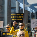 At the Picket Tesla protest organized by Rise and Resist (@risenresistnyc) on March 1, 2025, outside the Tesla Showroom at 860 Washington Street, NYC, demonstrators hold up bold signs calling for political change and billionaire accountability.
In the center of the image, a woman in a bright yellow coat and sunglasses raises a large black and yellow sign reading:
"OVERTHROW THE SHADOW PRESIDENT"
with the Rise and Resist (@risenresistnyc) website printed at the bottom.
To her right, another protester holds up a small whiteboard with a handwritten message:
"IMPEACH the Traitor TRUMP!!!"
In the background, more signs amplify the protest’s themes. A sign in red and black lettering reads:
"STOP THE COUP!"
while another partially visible sign states "MUSK", referencing criticism of Elon Musk. The protesters, dressed in sunglasses and warm clothing, engage passionately, chanting and raising their signs in front of the reflective glass of the Tesla showroom, which captures the surrounding cityscape.
This protest, led by Rise and Resist (@risenresistnyc), is part of the group’s continued activism against corporate greed, political corruption, and the influence of billionaires like Elon Musk and Donald Trump.