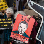 At the Picket Tesla protest organized by Rise and Resist (@risenresistnyc) on March 1, 2025, outside the Tesla Showroom at 860 Washington Street, NYC, demonstrators hold powerful signs condemning Elon Musk, corporate greed, and political corruption.
In the foreground, two older protesters stand side by side, holding bold, anti-Musk signs. The protester on the left, wearing a dark teal coat and sunglasses, holds a black and yellow sign reading:
"RESIST THE MUSK-TRUMP COUP"
with the Rise and Resist (@risenresistnyc) website displayed below.
Next to her, a protester in a pink quilted jacket grips a red sign featuring a stylized image of Elon Musk with the stark message:
"I AM STEALING FROM YOU."
The sign’s dramatic artwork and lettering emphasize accusations of wealth hoarding and economic exploitation by Musk.
In the background, additional demonstrators hold signs, including one in yellow that reads "DOGE IS A CRIMINAL ENTERPRISE," referencing Musk’s involvement in cryptocurrency. A large black-and-white cardboard cutout of Musk in a suit with a raised arm looms over the protesters, reinforcing the anti-oligarch message. Further back, a small cutout figure of Donald Trump can be seen, highlighting the political connections being criticized by the group.
The Rise and Resist (@risenresistnyc) protest targets Elon Musk’s economic influence, Tesla’s corporate practices, and billionaire control over government and resources. Protesters of all ages participate, holding signs and chanting in front of Tesla’s showroom, merging activism with a striking visual protest.
