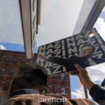At the Picket Tesla protest organized by Rise and Resist (@risenresistnyc) on March 1, 2025, outside the Tesla Showroom at 860 Washington Street, NYC, a protester raises a striking sign featuring an altered image of Elon Musk in a salute-like pose with the repeated bold text "NAZI" in the background.
Captured from behind, the protester wears a camouflage cap and a blue jacket with a tan collar, holding the sign high against the bright blue sky. The angle of the shot emphasizes the contrast between the urban setting, the Tesla showroom’s modern awning, and the red-brick buildings in the background. Sunlight reflects off the sign, drawing attention to the provocative message.
This image encapsulates the bold and confrontational nature of the protest, as activists denounce Musk’s influence over politics, corporations, and economic policies. The Rise and Resist (@risenresistnyc) protest is part of their broader movement against billionaire power, corporate corruption, and social injustice.