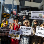 At the Picket Tesla protest on March 1, 2025, outside the Tesla Showroom at 860 Washington Street, NYC, demonstrators stage a theatrical performance portraying wealthy elites benefiting at the expense of working-class Americans. Dressed in extravagant attire, faux fur coats, pearls, sequins, and crowns, the group mockingly holds signs with messages such as:
"Your Tax Hike Will Fund My Botox"
"Your Post Office Closure Will Fund My Space Adventure"
"Your Benefits Will Fund My Golf Lessons"
One protester wears a red dress, pearls, and a feathered hat, another dons a leopard-print fur coat with oversized sunglasses, while a man in a sequined black jacket and crown drapes an iridescent scarf around his neck, holding a glitter-covered champagne bottle. The Tesla showroom is visible in the background, reinforcing their critique of corporate and billionaire influence in politics.
Behind them, other protesters hold additional signs, including one that reads, "This is the Immigrant Who Took Your Job," featuring an image of Elon Musk. The performance serves as a sharp commentary on economic disparity, wealth hoarding, and government policies that favor the ultra-rich.