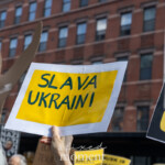 At the Picket Tesla protest organized by Rise and Resist (@risenresistnyc) on March 1, 2025, outside the Tesla Showroom at 860 Washington Street, NYC, a demonstrator holds up a yellow and blue handmade sign reading "SLAVA UKRAINI", a Ukrainian national slogan meaning "Glory to Ukraine."
The sign is prominently displayed in the crowd, with a red brick building in the background. Nearby, other protest signs are partially visible, including one that reads "OLIG..." likely referencing "OLIGARCHS", connecting the anti-Musk protest to broader concerns about authoritarianism, wealth hoarding, and geopolitical power struggles.
A large cardboard cutout of a raised fist appears in the background, symbolizing solidarity and resistance. The combination of anti-Musk, anti-oligarchy, and pro-Ukraine messaging reflects the intersectionality of global activism, linking corporate accountability with larger political movements.
This demonstration by Rise and Resist (@risenresistnyc) underscores concerns over billionaire influence, democracy, and international affairs, with protesters drawing connections between economic justice, global conflicts, and the role of corporations like Tesla in shaping political narratives.
