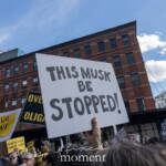 At the Picket Tesla protest organized by Rise and Resist (@risenresistnyc) on March 1, 2025, outside the Tesla Showroom at 860 Washington Street, NYC, demonstrators rally with bold signs against Elon Musk's influence, corporate power, and political entanglements.
A prominent white sign with black lettering reads:
"THIS MUSK BE STOPPED!"
It is held high amidst a sea of protest placards. In the lower left, another demonstrator raises a yellow and blue sign reading "SLAVA UKRAINI", expressing solidarity with Ukraine. Additional signs in the crowd reinforce the message of corporate and political resistance, including:
"OVERTHROW THE OLIGARCHS"
"MAKE NO MISTAKE, THIS IS A COUP"
"THIS BILLIONAIRE STOLE YOUR SOCIAL SECURITY NUMBER"
The backdrop of red brick buildings, a blue sky, and a "STOP" street sign visually underscores the urgency of the demonstration. A cardboard cutout of a raised fist, symbolizing resistance and defiance, is also visible.
This demonstration by Rise and Resist (@risenresistnyc) brings together economic justice activists, political critics, and international solidarity movements, connecting corporate accountability with global issues. The mix of messages, from economic concerns to geopolitical activism, reflects the broad scope of the protest.