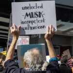 At the Picket Tesla protest organized by Rise and Resist (@risenresistnyc) on March 1, 2025, outside the Tesla Showroom at 860 Washington Street, NYC, demonstrators raise signs condemning Elon Musk’s growing political and corporate power.
A protester in a navy jacket stands with their arms raised, holding a handmade sign that reads:
"Unelected – MUSK – incompetent, unAmerican."
The sign critiques Musk’s influence over government policies and his perceived corporate overreach.
In the background, other signs convey similar messages, including:
"STOP THE REAL STEAL", referencing concerns over democratic integrity and corporate takeovers.
"THIS BILLIONAIRE IS KILLING OUR GOVERNMENT", linking Musk’s power to economic and political manipulation.
"PINK SLIP", possibly symbolizing a call to remove Musk from influence.
The diverse crowd includes people of different ages and backgrounds, many wearing hats, sunglasses, and jackets while engaging in chanting and sign-waving. The Tesla showroom's glass facade reflects the urban environment, contrasting the corporate setting with the grassroots energy of the protest.
The demonstration, led by Rise and Resist (@risenresistnyc), emphasizes concerns over wealth concentration, political influence, and the unchecked power of billionaires like Elon Musk.