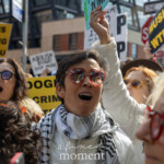 At the Picket Tesla protest on March 1, 2025, in front of the Tesla Showroom at 860 Washington Street, NYC, a woman wearing a white jacket, a black-and-white keffiyeh, and heart-shaped red sunglasses passionately shouts, raising her fist in the air. Surrounding her, other protesters chant and hold bold signs reading "MUSK IS STEALING FROM YOU," "DOGE IS A CRIMINAL ENTERPRISE," and "MUSK WTF?" The demonstrators express outrage over billionaire influence, economic injustice, and perceived corporate corruption.
The energy of the crowd is intense and determined, with people of diverse backgrounds raising their voices in unison against Musk’s policies. Many participants wear symbolic accessories, such as sunglasses, scarves, and hats, adding personality and defiance to their protest stance. Their synchronized shouting and raised fists highlight a collective frustration with corporate power and economic inequality.
The Rise and Resist movement (@riseandresistnyc) organized this action to protest Musk’s financial and political reach, calling attention to issues like tax breaks for billionaires, Dogecoin manipulation, and threats to public benefits like Social Security and Medicare. The Tesla showroom’s glass windows reflect the fervor of the protest, symbolizing a clash between corporate wealth and grassroots activism.