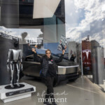 A protester stands inside the Tesla Showroom at 860 Washington Street, NYC, during the Picket Tesla protest on March 1, 2025, holding two bold signs. One sign reads "THIS BILLIONAIRE IS DESTROYING OUR COUNTRY" while the other repeatedly states "NAZI" alongside an altered image of Elon Musk. The individual is dressed in black, wearing a "True Indivisible" hoodie and a puffer jacket.
Behind the protester, the Tesla Cybertruck is prominently displayed, alongside a Tesla Bot (Optimus) exhibit, representing the company's vision of automation and AI-powered robotics. The scene is captured through the showroom's glass windows, reflecting the outside protesters, cityscape, and banners.
This protest was part of the Rise and Resist NYC (@riseandresistnyc) movement, aiming to boycott Tesla and condemn Musk's influence on politics, media, and wealth concentration. The demonstration brought activists together to challenge corporate power and its role in economic and political systems.