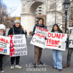 A group of activists, including adults and children, participate in the Women's March on March 8th, 2025, at Washington Square Park, New York City. Standing in front of the iconic Washington Square Arch, they hold several handmade signs expressing strong anti-Trump sentiments.
From left to right:
A child dressed warmly in a thick white winter hat, black coat, and holding a sign that reads: "DONALD, YOU have FAILED US"
An adult wearing a grey knit hat, black jacket, colorful scarf, and sneakers holding a sign creatively spelling out the acronym "TRUMP": "Tyrant, Rapist, Unqualified, Misogynist, Panderer"
Two young people in casual clothing, one holding a sign stating clearly: "TRUMP RAPIST TRUMP THE CRIMINAL"
and the other one displaying:
"DUMP TRUMP" featuring an illustration of a trash can with Trump's face inside it.
An older man wearing a dark coat, grey pants, baseball cap, and brown shoes, presenting a sign that reads: "FELON AND THE FELON"
The atmosphere conveys strong political dissent, emphasizing accountability and justice, as part of the larger Women's March rally for social and political change.